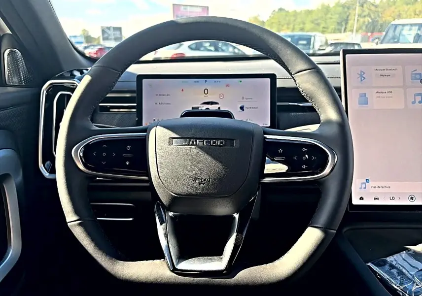 Vue centrée sur le volant noir du JAECOO J7 1.5 tgdi 224 select avec écran numérique et écran tactile à droite.