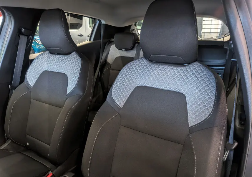 Vue intérieure rapprochée des sièges avant en tissu noir et gris avec motif losange de la Renault Clio V 2025.