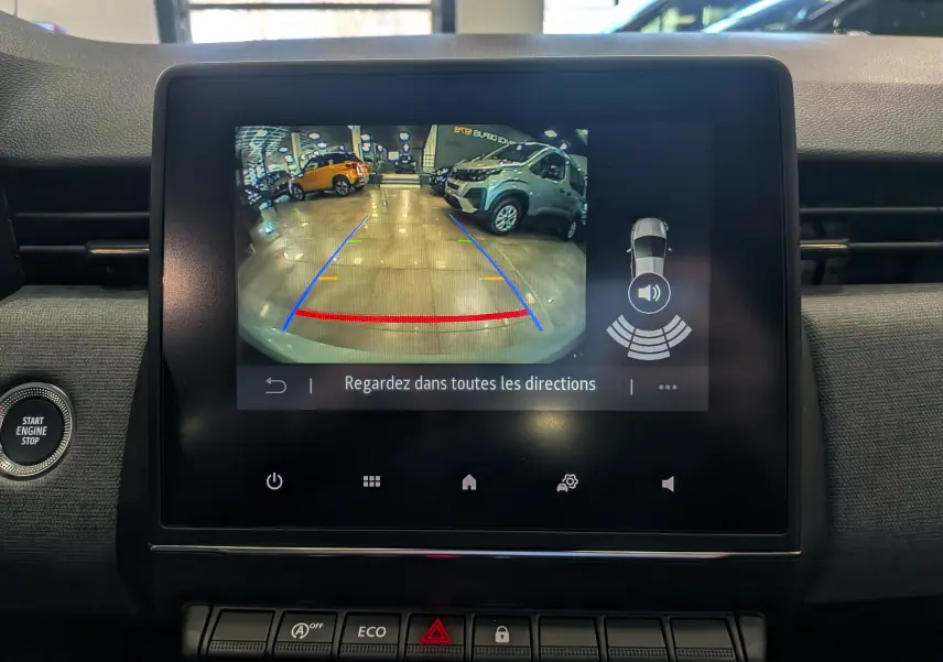 Écran central de la Renault Clio V gris Rafale montrant la caméra de recul avec lignes de guidage et alertes sonores.