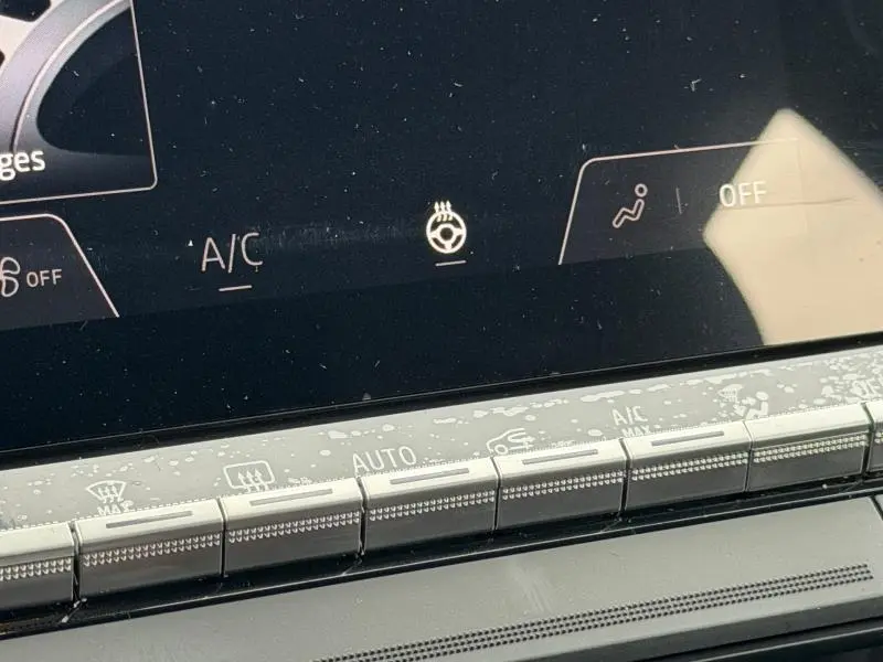 Gros plan sur les commandes de climatisation et écran tactile du tableau de bord du Renault Captur blanc nacré/noir.