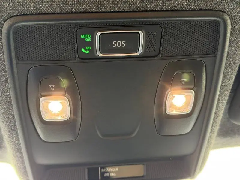 Vue intérieure en contre-plongée du plafonnier noir avec éclairages de lecture allumés et bouton SOS du Renault Captur 2026.