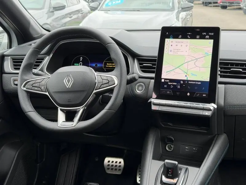 Vue intérieure du tableau de bord du Renault Captur 2026, volant cuir multifonction et écran tactile vertical avec navigation.