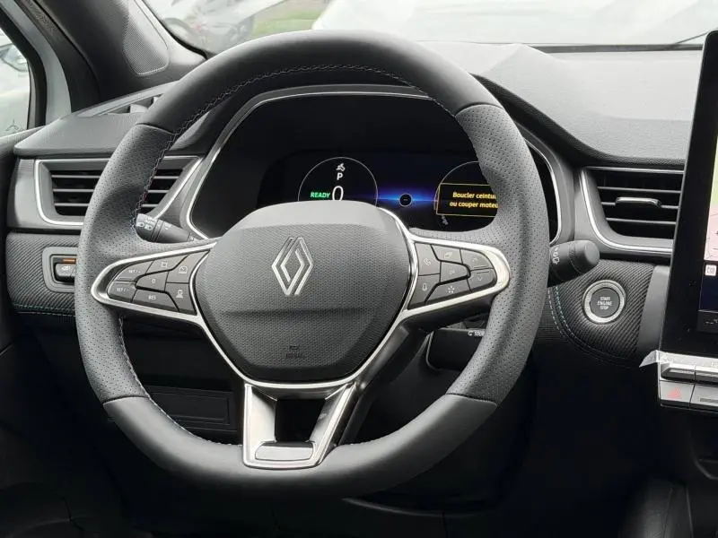 Vue rapprochée du volant cuir perforé noir avec commandes multifonctions du Renault Captur hybride 2026.