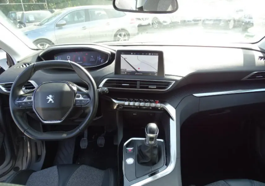 Vue intérieure frontale du Peugeot 3008 gris Artense 2017, avec tableau de bord numérique et console centrale équipée de touches piano chromées.