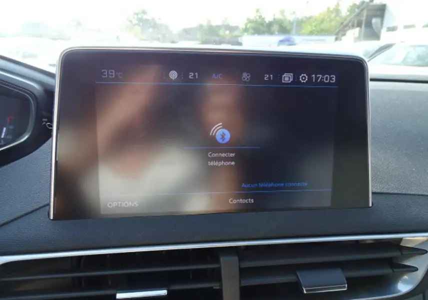 Écran tactile central du tableau de bord du Peugeot 3008 2017, avec commandes climatisation et connectivité visible.