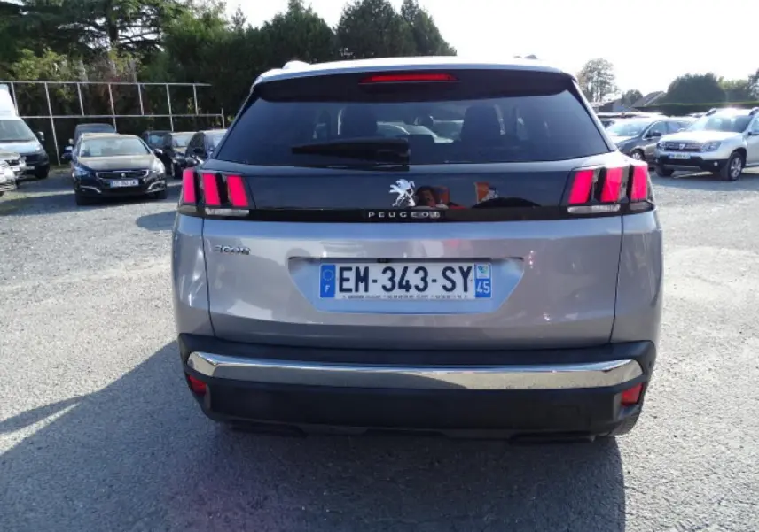 Vue arrière d’un Peugeot 3008 gris Artense avec feux arrière à trois griffes et bandeau noir brillant.