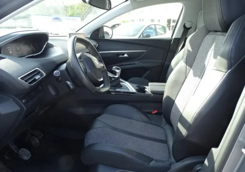 Vue intérieure côté conducteur du Peugeot 3008 2017, sièges bi-matière noirs et gris avec volant compact et levier de vitesse manuel.