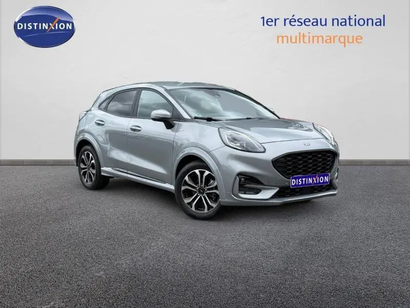 Ford Puma 1.0 EcoBoost 155ch mHEV ST-Line gris clair, vue 3/4 avant droit, calandre noire et jantes alliage.