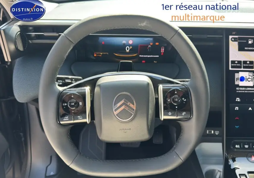 Vue rapprochée du volant multifonction noir du Citroën C5 Aircross 2026 avec tableau de bord numérique et écran tactile.