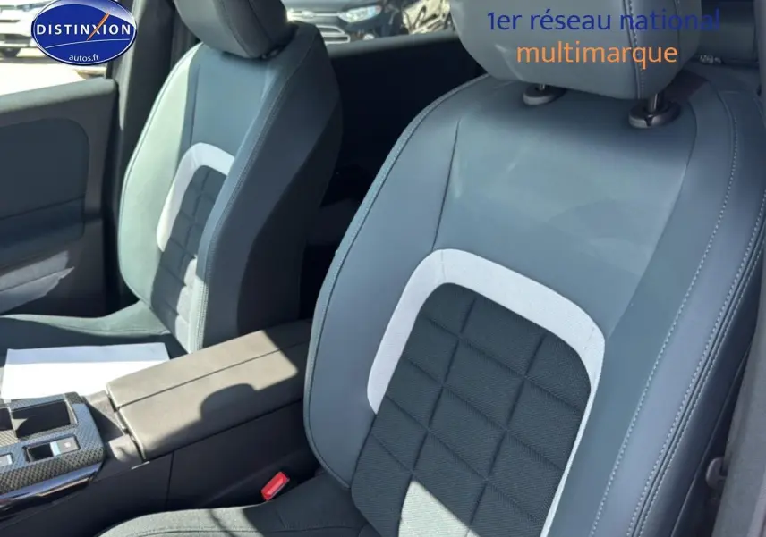 Gros plan sur les sièges avant gris clair et noir du Citroën C5 Aircross 2026, avec accoudoir central visible.