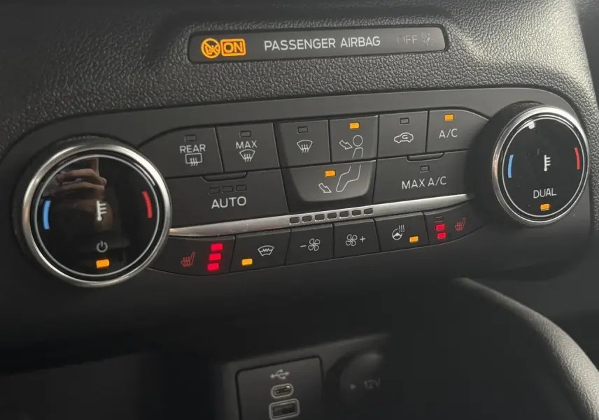 Détail du tableau de bord du Ford Kuga 2023 montrant la climatisation automatique et les commandes de sièges chauffants.