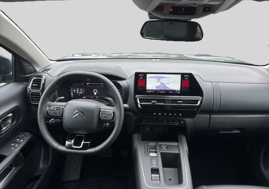 Vue intérieure avant du Citroën C5 Aircross gris platinium 2025, volant multifonction et écran tactile GPS visible.