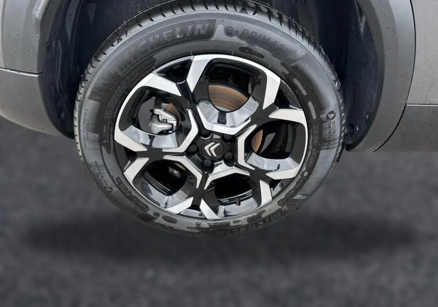 Gros plan sur la jante alu noire et argentée avec logo Citroën du Citroën C5 Aircross gris platinium.