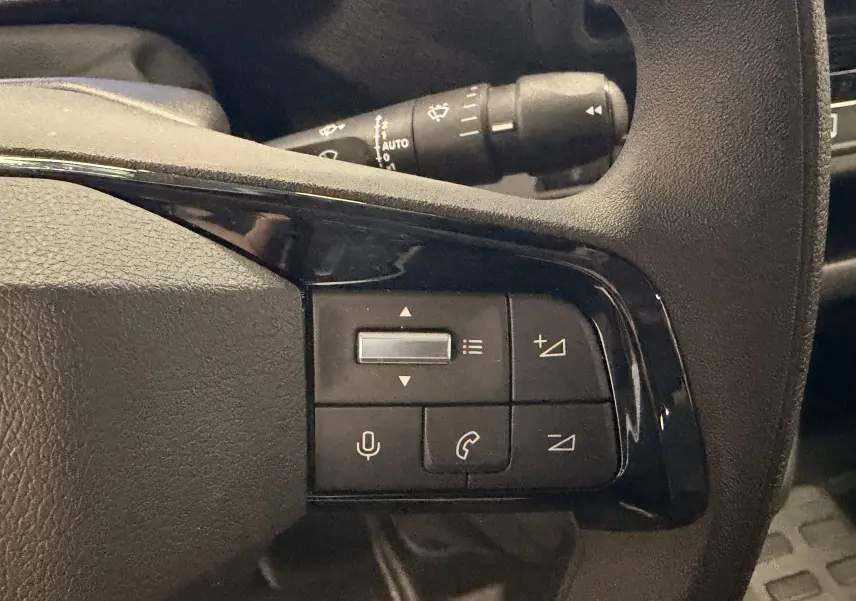 Gros plan sur les commandes multifonctions noires situées à droite du volant dans l'habitacle du Citroën Jumpy gris titanium.