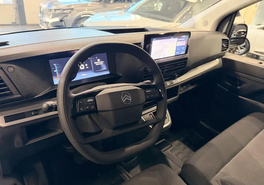 Intérieur du Citroën Jumpy cabine approfondie 2025, vue du poste de conduite avec écran tactile et volant multifonction noir.