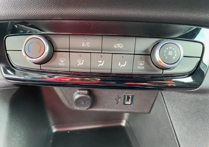 Panneau de commande de climatisation manuelle avec boutons et molettes dans une Opel Corsa gris Magnetic 2022.