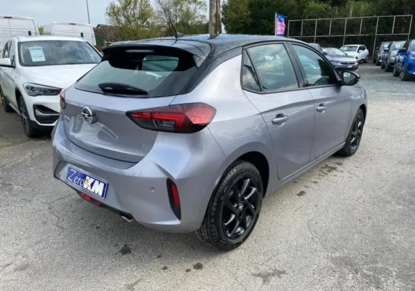 Opel Corsa gris magnetic vue 3/4 arrière droit avec toit noir et jantes alliage noires brillantes.