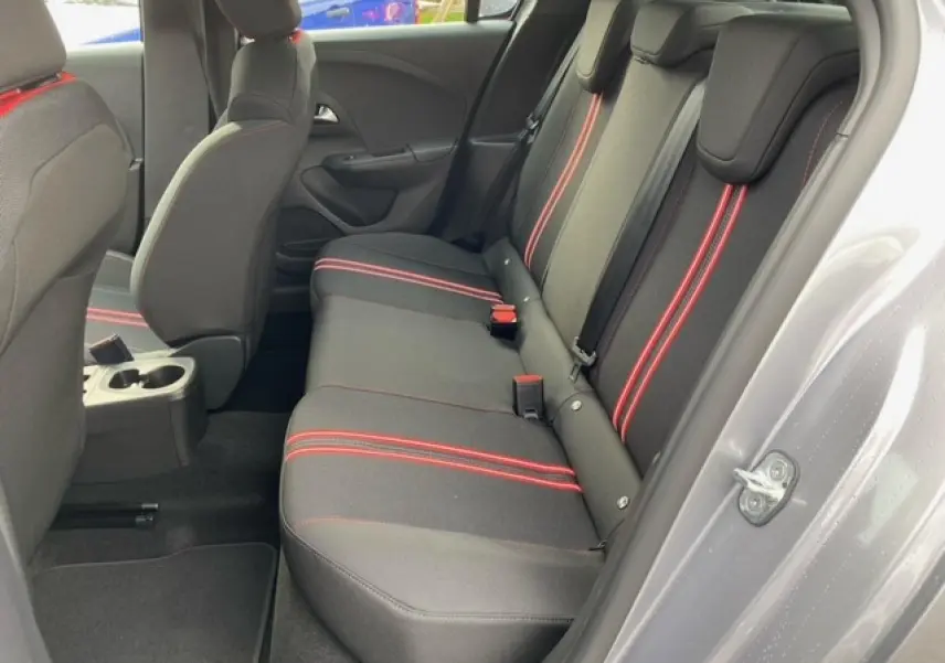 Vue côté droit de l'habitacle arrière de l'Opel Corsa 2022, sellerie tissu noire avec bandes rouges contrastantes.