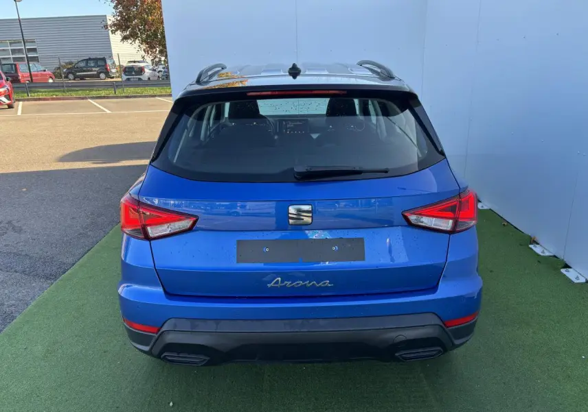 Vue arrière d'un SEAT Arona bleu saphir avec toit noir, feux arrière LED et double sortie d'échappement intégrée.