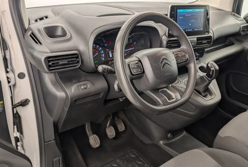 Vue intérieure côté conducteur du Citroën Berlingo Van blanc, avec tableau de bord noir et écran tactile central.