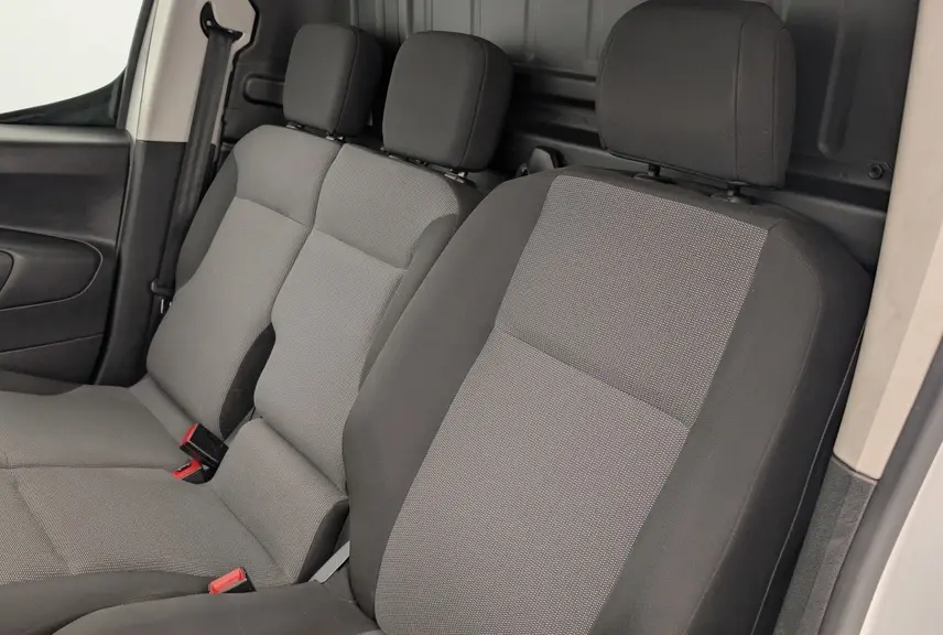 Vue intérieure côté conducteur du Citroën Berlingo Fourgon 2020, sièges tissu gris Mica et cloison cabine noire.