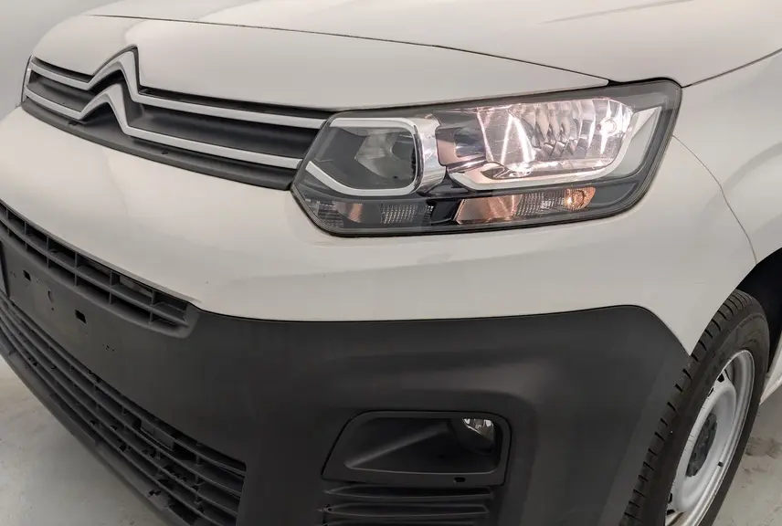 Vue 3/4 avant droit du Citroën Berlingo Van blanc Banquise avec phares allumés et pare-chocs noir mat.