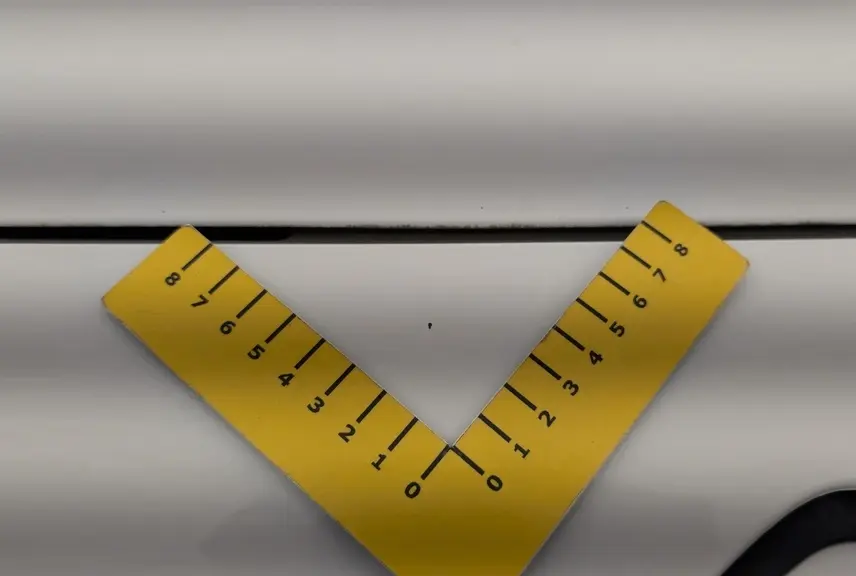 Gros plan sur une rayure fine sur la carrosserie blanche banquise du Citroën Berlingo Fourgon côté droit.