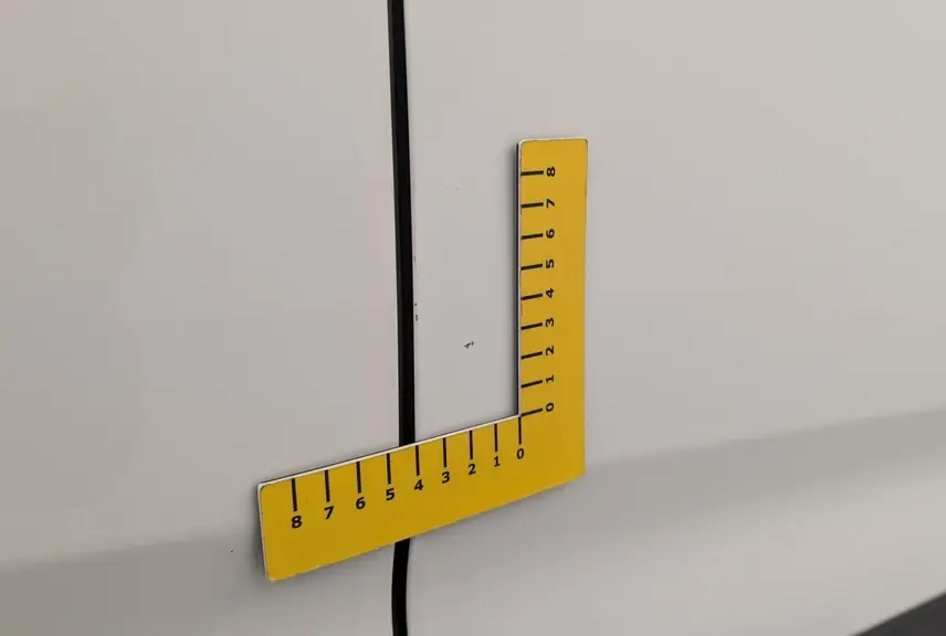 Gros plan sur une rayure fine sur la porte blanche banquise du Citroën Berlingo Fourgon côté droit.