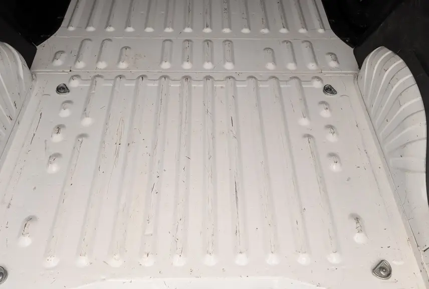 Vue plongeante sur la zone de chargement blanche du Citroën Berlingo Fourgon avec anneaux d'arrimage au sol visibles.