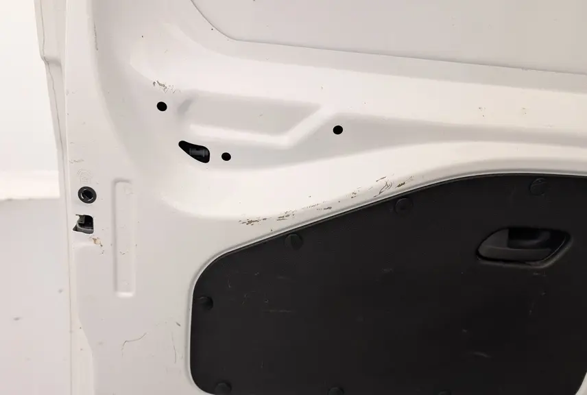 Gros plan sur la porte arrière gauche blanche Banquise du Citroën Berlingo Fourgon 2020 avec panneau intérieur noir et poignée intégrée.