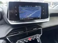 Vue intérieure du tableau de bord de la Peugeot 208 1.2 PureTech 100 Style 2021, écran tactile affichant la navigation.