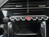 Gros plan sur la console centrale de la Peugeot 208 1.2 PureTech 100 Style 2021, montrant les commandes et boutons en gris.