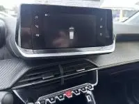 Gros plan sur l'écran tactile et la console centrale de la Peugeot 208 1.2 PureTech 100 Style gris, intérieur moderne et épuré.