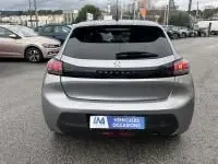 Vue arrière d'une Peugeot 208 gris 1.2 PureTech 100 Style essence 2021, avec feux arrière étirés et logo central noir.