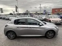 Vue de profil côté gauche d'une Peugeot 208 gris 1.2 PureTech 100 Style essence 2021 avec jantes alliage, stationnée en extérieur.