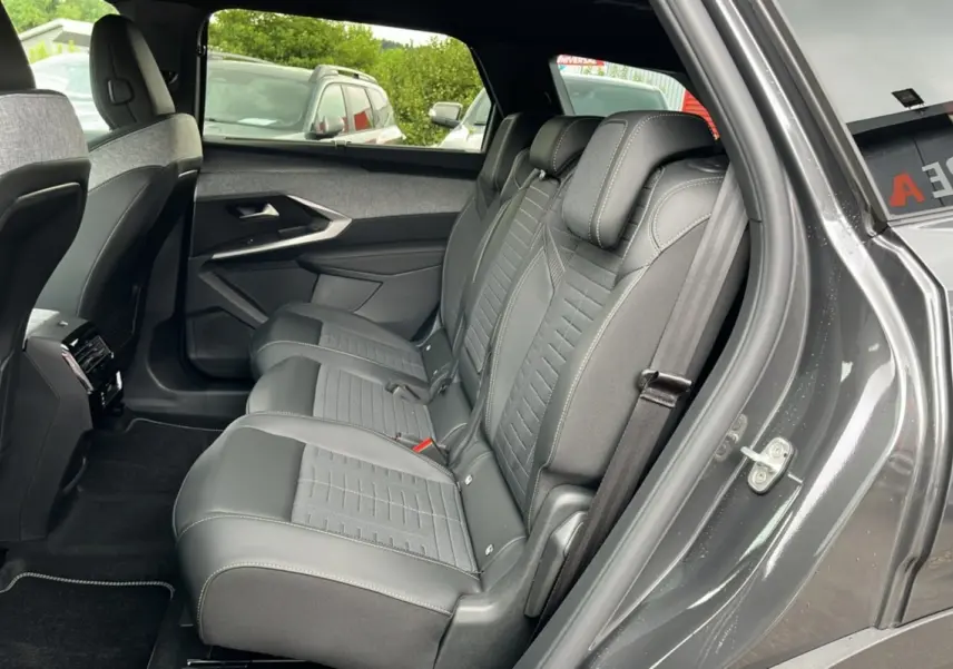 Vue côté droit sur la banquette arrière en cuir et tissu gris du Peugeot 5008 Hybrid 145 avec porte ouverte.