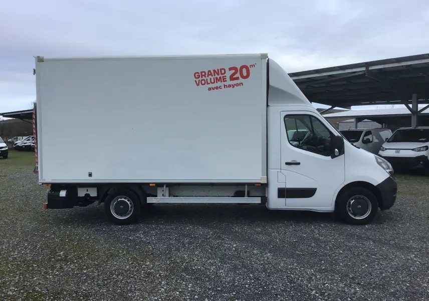 Vue de profil droit d’un utilitaire blanc Opel Movano L3H1 avec caisse volume 20 m³ et hayon électrique, stationné sur sol gravillonné.