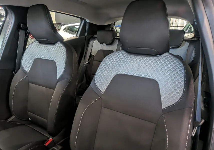 Vue intérieure rapprochée des sièges avant en tissu noir et gris avec motifs losanges de la Renault Clio V 2025.