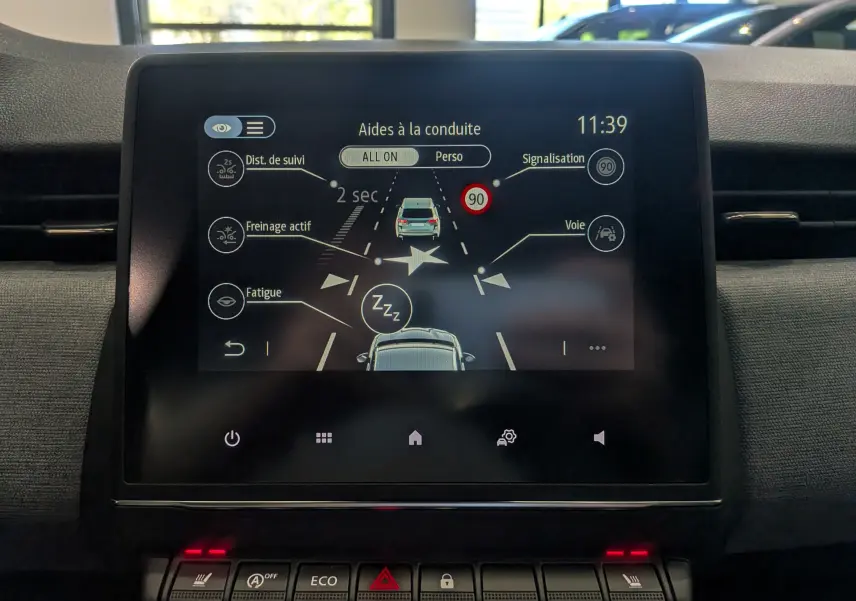 Écran tactile central de la Renault Clio V gris schiste montrant les aides à la conduite et les alertes actives.