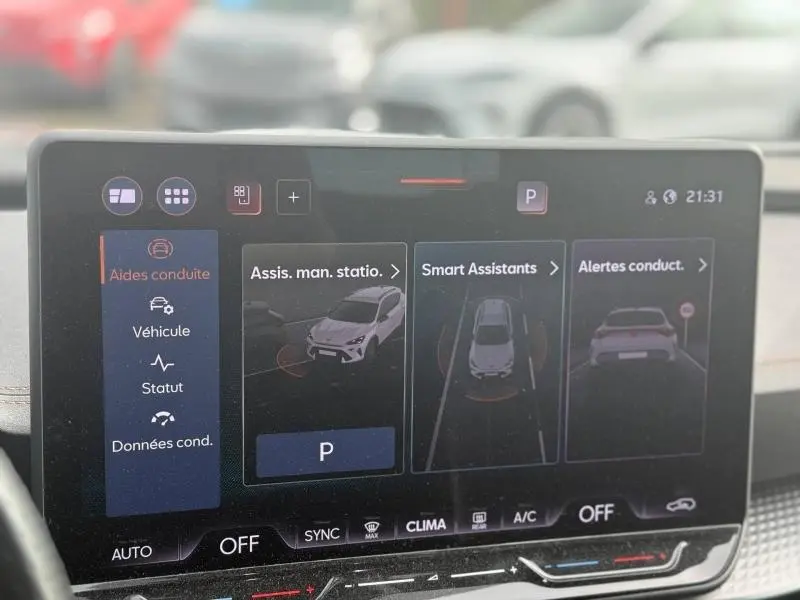 Écran tactile central du tableau de bord montrant les aides à la conduite du CUPRA Formentor bleu, vue intérieure frontale.