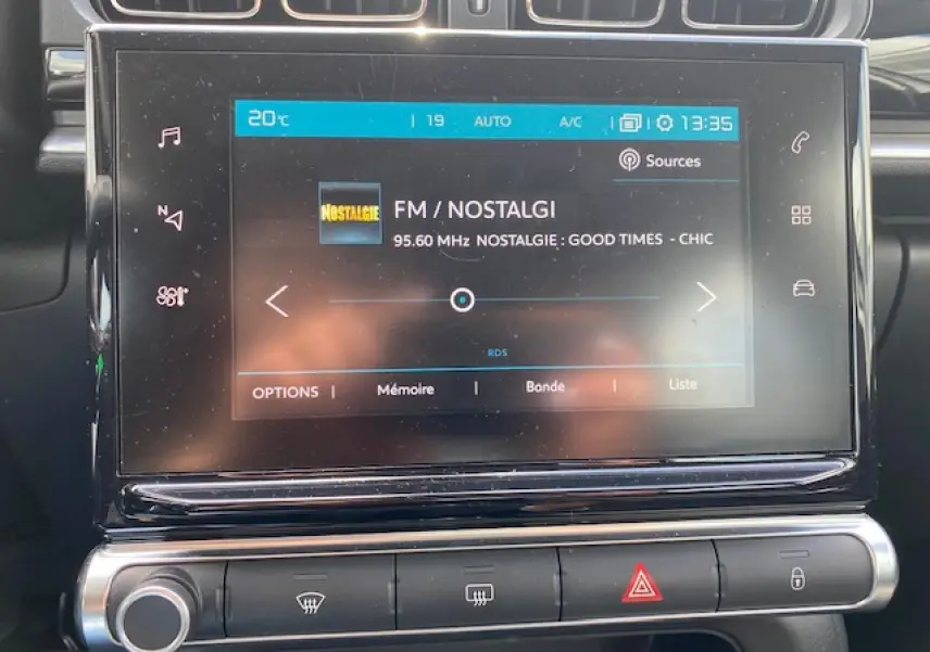 Vue rapprochée de l'écran tactile central du tableau de bord de la Citroën C3 gris clair, affichant la radio FM.