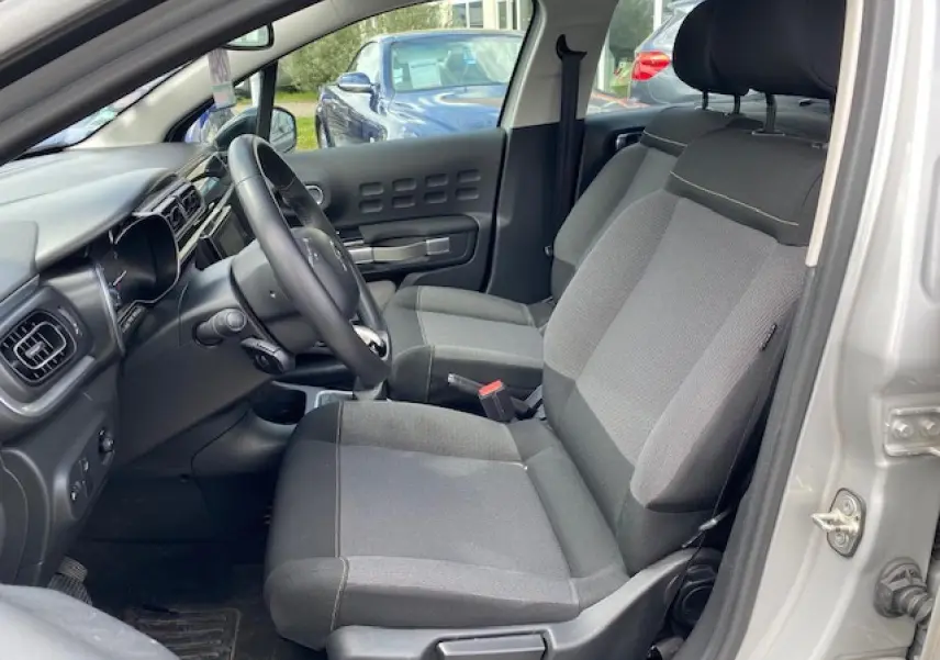 Vue intérieure côté conducteur de la Citroën C3 gris clair, montrant les sièges en tissu Mica Grey et le tableau de bord.