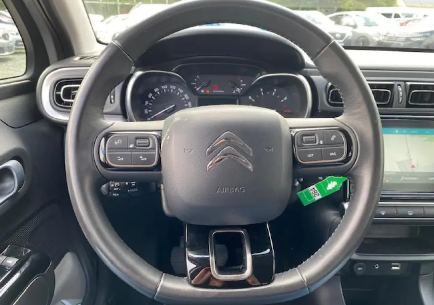 Vue frontale du volant noir de la Citroën C3 2017 avec commandes intégrées et tableau de bord visible.