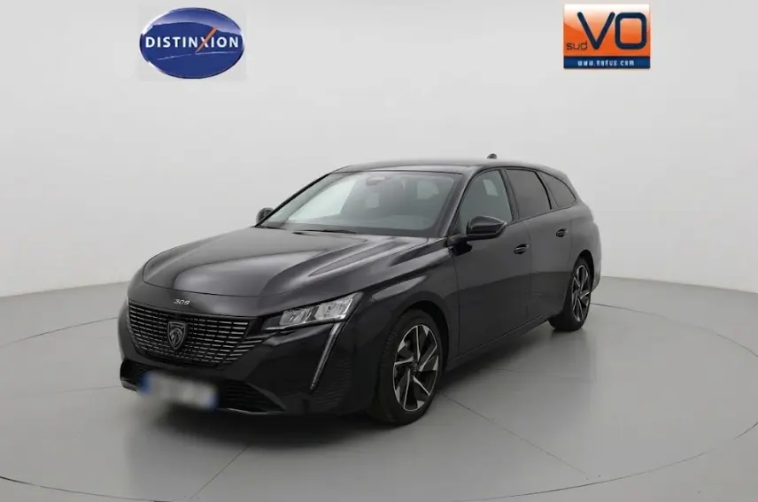 Peugeot 308 SW Hybrid noir vue 3/4 avant droit, avec calandre distinctive et phares LED fins.