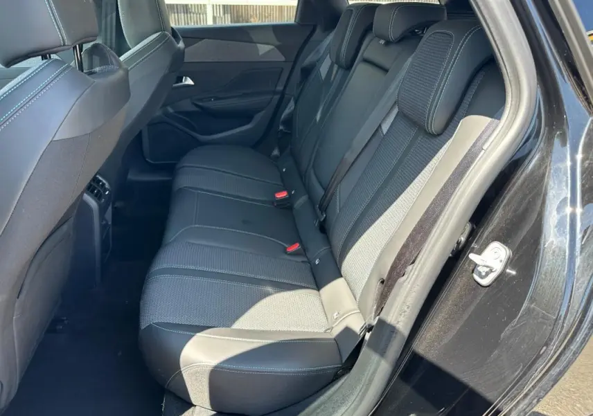 Vue côté droit des sièges arrière noirs en tissu et cuir du Peugeot 308 SW Hybrid 145 e-DCS6 Allure 2025.