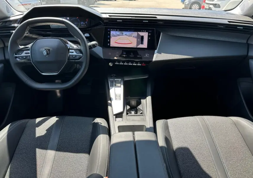 Vue intérieure avant du Peugeot 308 SW Hybrid 145 e-DCS6 Allure 2025, avec tableau de bord numérique et écran tactile central.