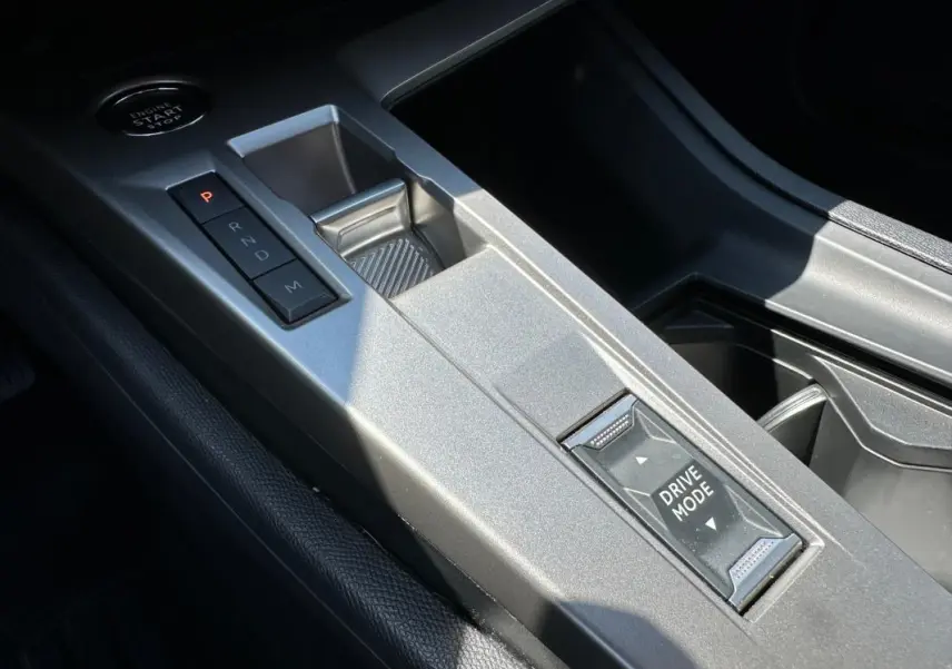 Gros plan sur la console centrale argentée du Peugeot 308 SW Hybrid 145, avec boutons de boîte auto et mode de conduite.