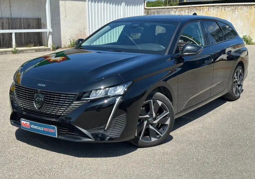 Peugeot 308 SW Hybrid 145 noir vue 3/4 avant droit, avec calandre distinctive et jantes alliage modernes.