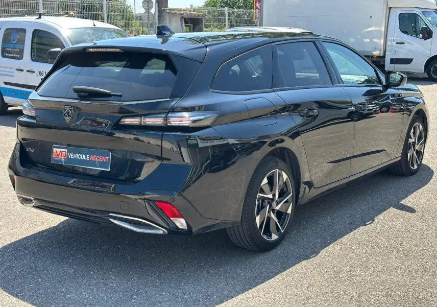Peugeot 308 SW Hybrid noir vue 3/4 arrière droit, avec feux arrière LED et jantes alliage distinctives.