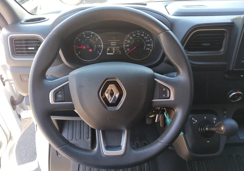 Vue rapprochée du volant noir de Renault Master blanc 2020, avec tableau de bord et commandes visibles.